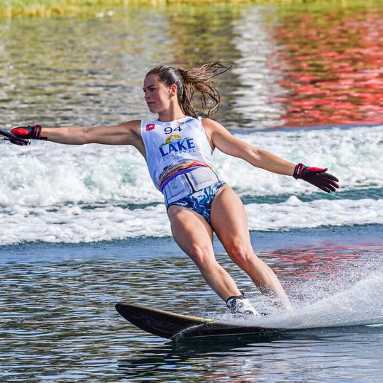 Neilly Ross mid-turn on a trick ski, spray rising behind her