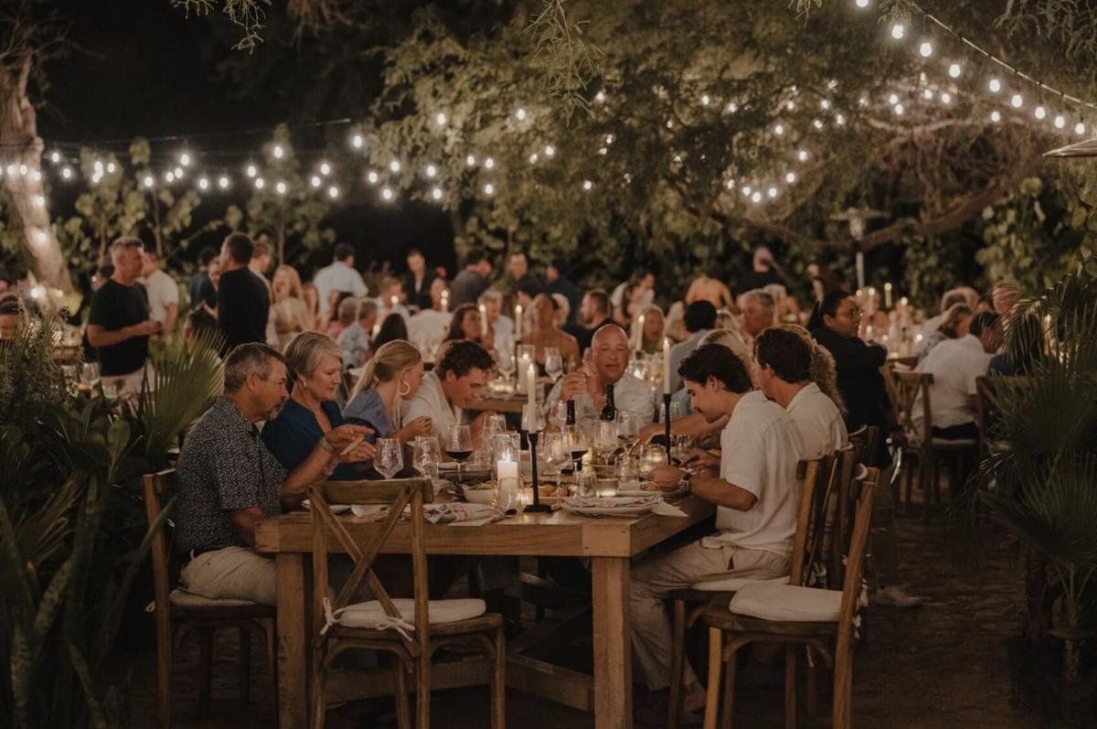 A long table set for dinner under string lights at Marina Village